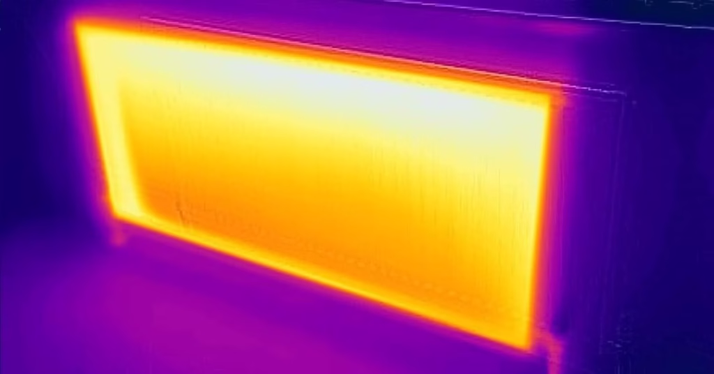 Hot radiator glowing orange and yellow on a thermal imaging camera