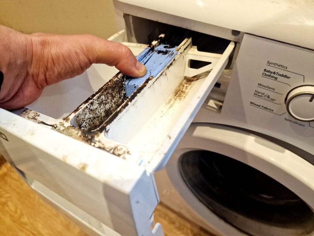 Dirty washing machine drawer being removed