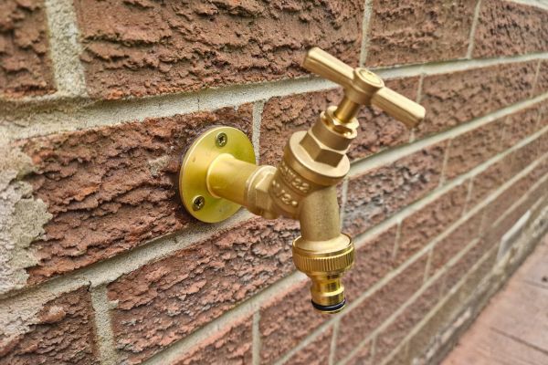 Outside tap fitted to brick wall.