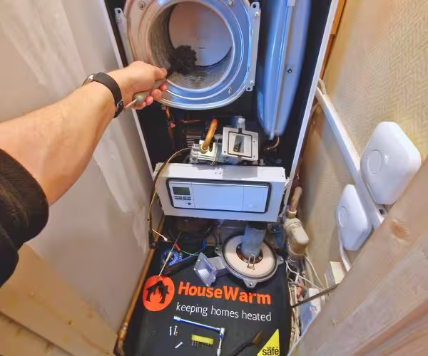 HouseWarm engineer cleaning boiler heat exchanger during annual service in Wallsend HouseWarm engineer cleaning boiler heat exchanger during annual service in Wallsend
